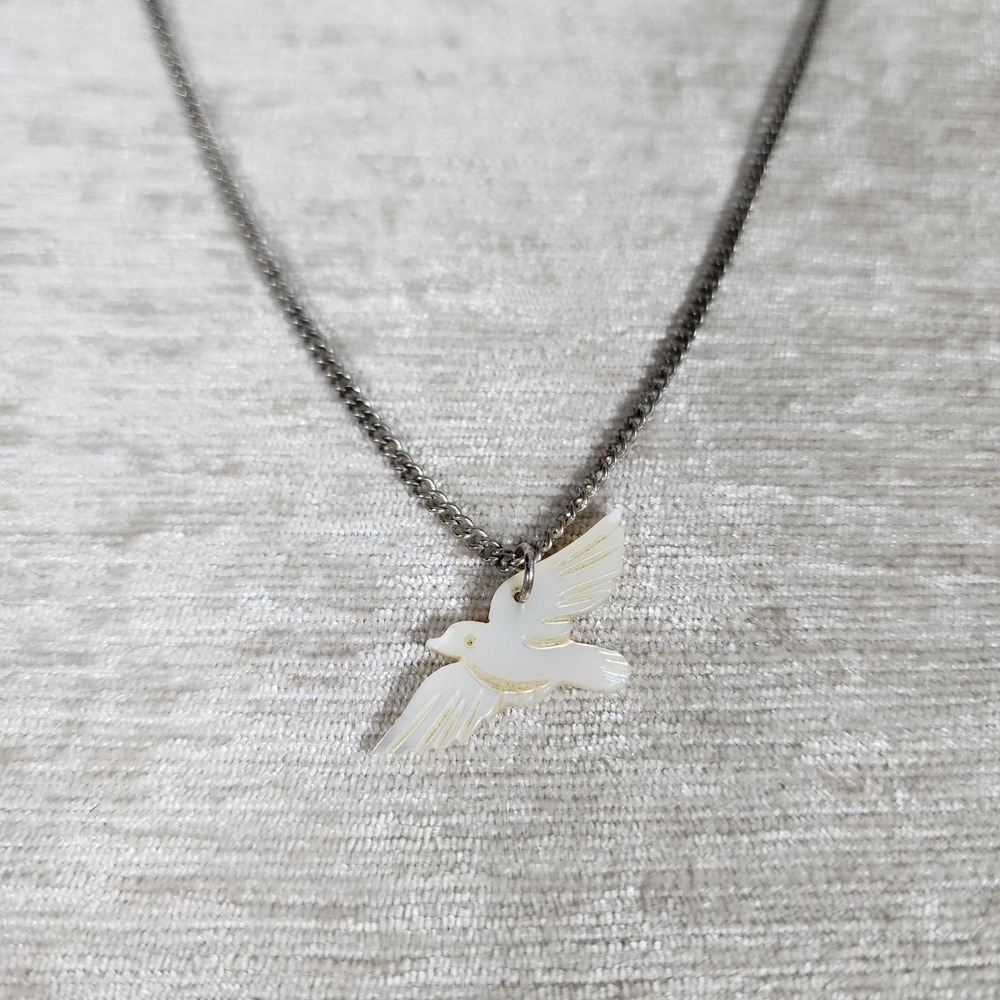 Vintage silver tone necklace featuring a white mother-of-pearl dove pendant